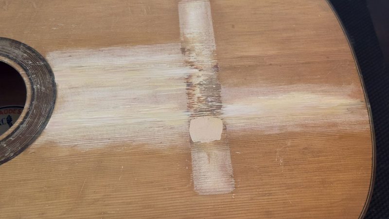 The brittle old shellac made the crack repairs more difficult and led to partial refinishing.