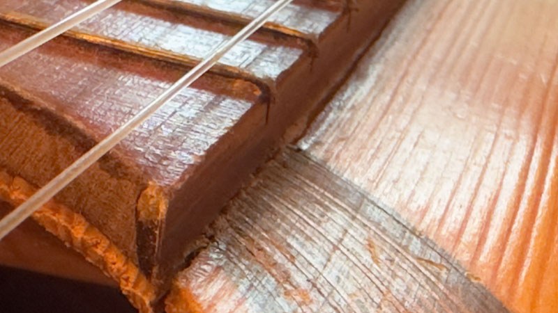 The guitar top was cracked along both sides of the fingerboard.